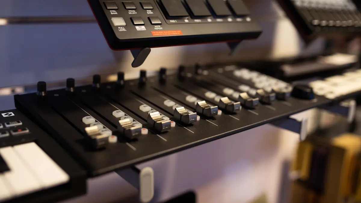 A close-up view of professional audio mixing equipment in a studio setting.